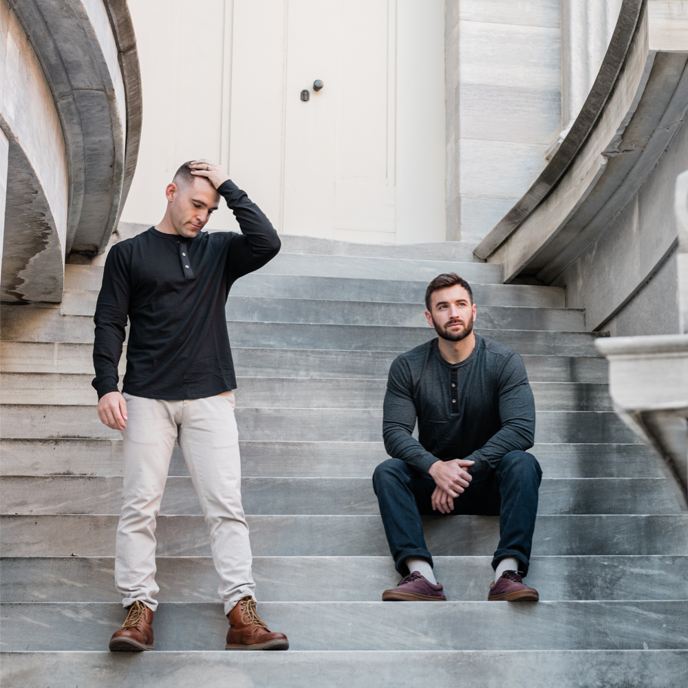 Two men wearing Henley's on a staircase