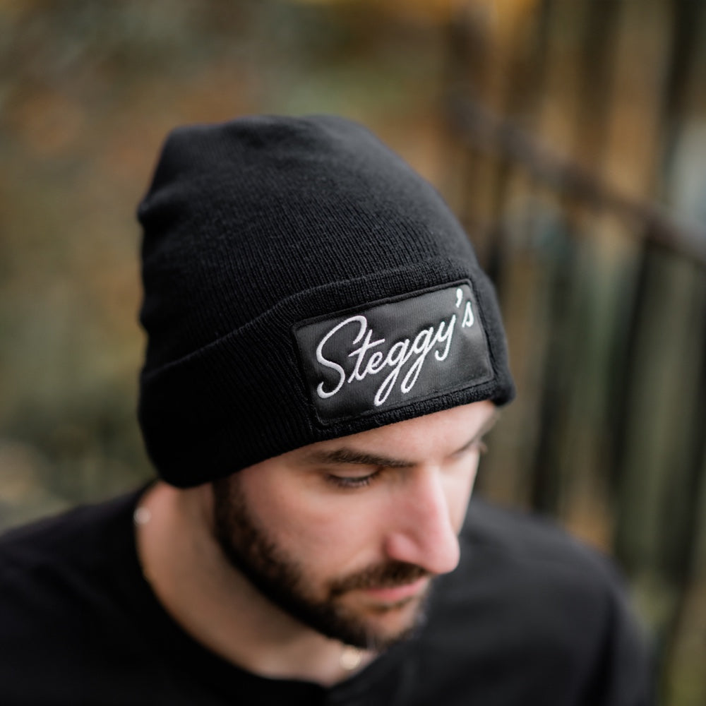 Man wearing a Steggy's beanie in the forest