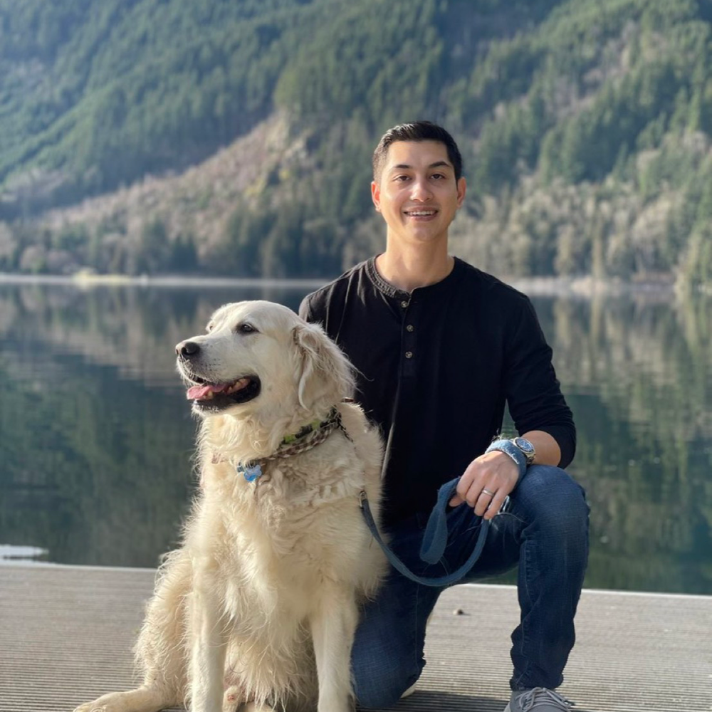 Picture of a man wearing a black henley next to a dog