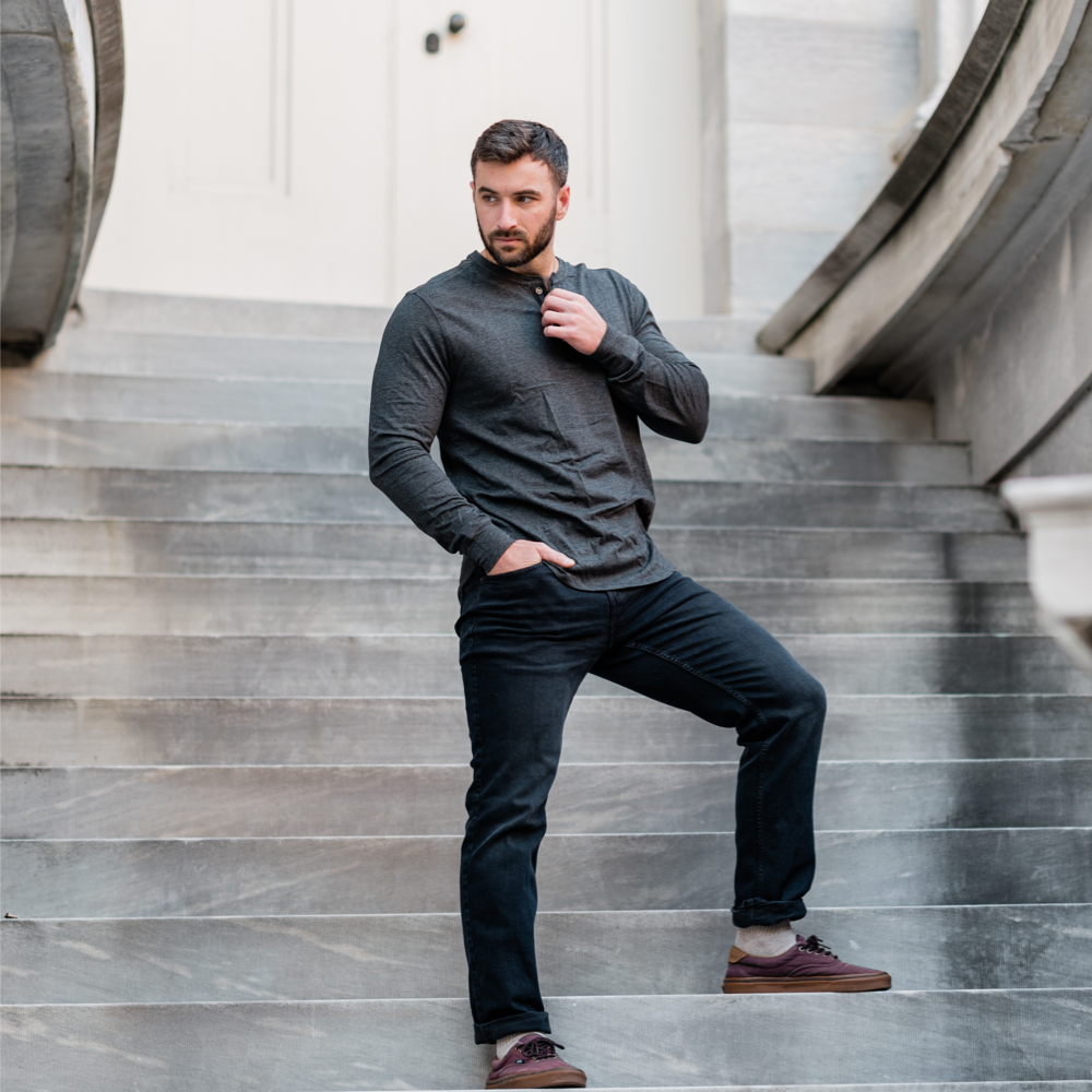 Man wearing a grey Henley posing on a staircase
